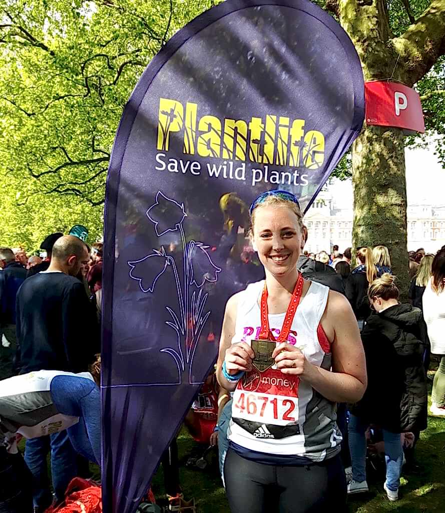 A female runner with a medal.